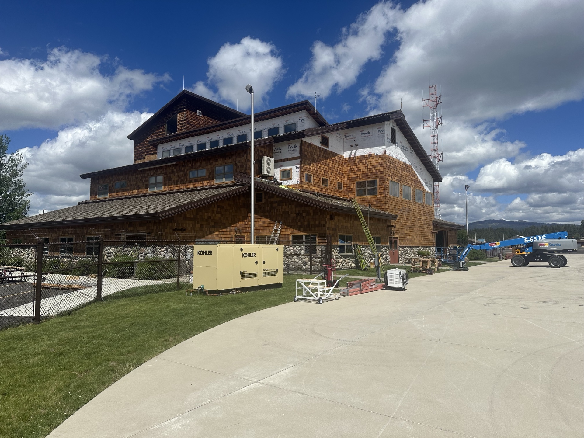 During photo of McCall Smoke Jumper Base main building — new cedar shake siding installed on lower sections, upper sections still in Tyvek wrap
