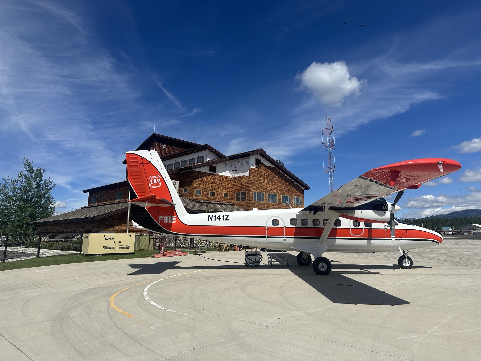 After photo of McCall Smoke Jumper Base main building with US Forest Service fire plane N141Z parked in front — completed cedar shake siding