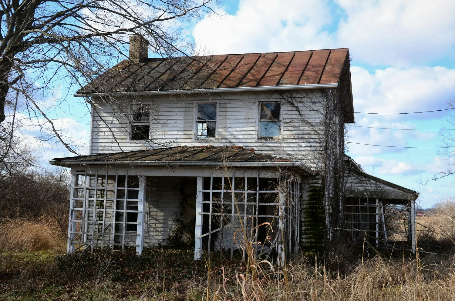 Older home with rusty roof surface before roof replacement planning