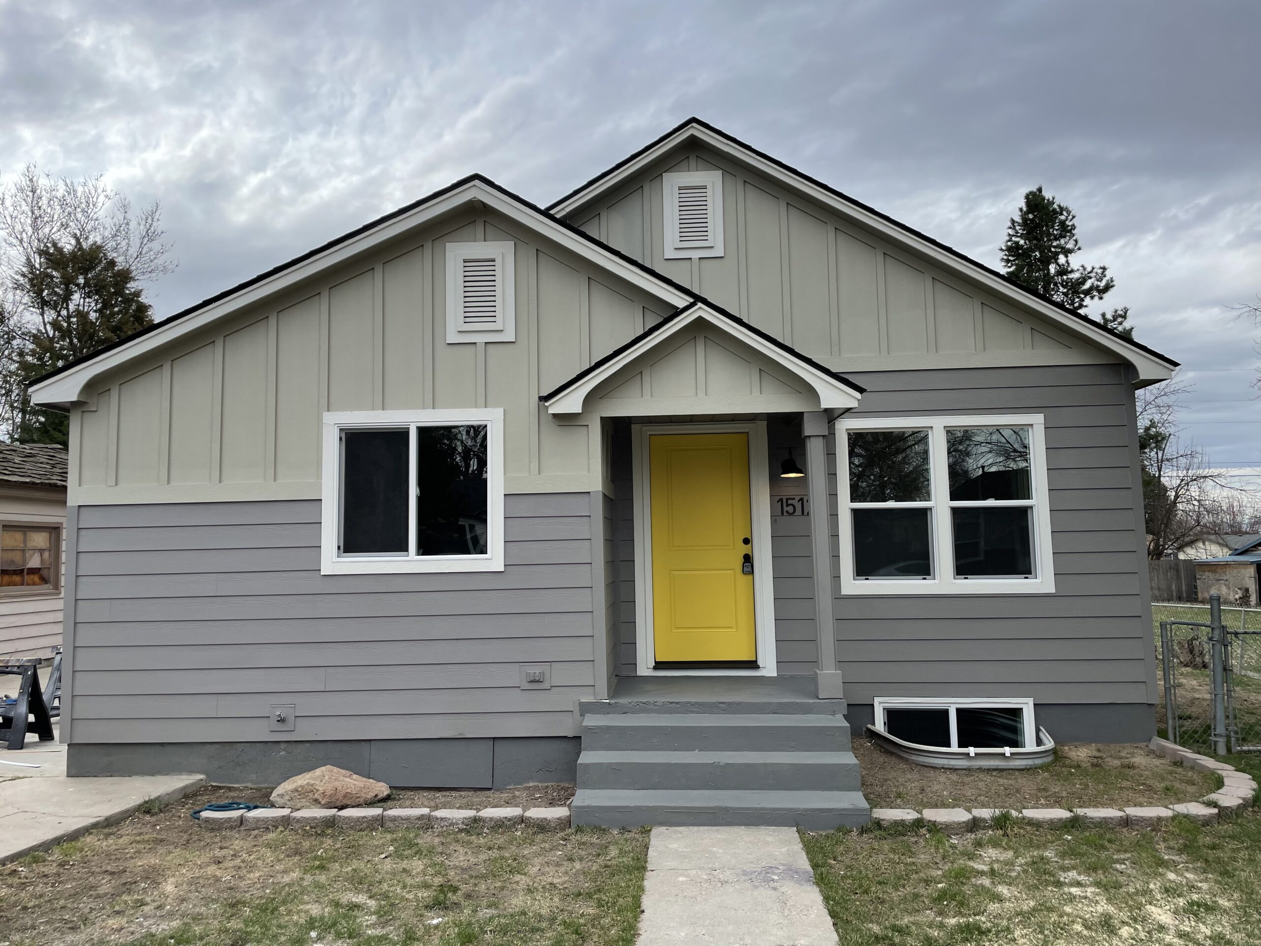 one-story home siding project with yellow door